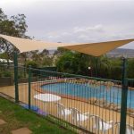 Cream shade sail over pool