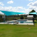 Green shade sail over pool