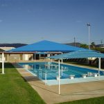 Blue striped shade structure over pool