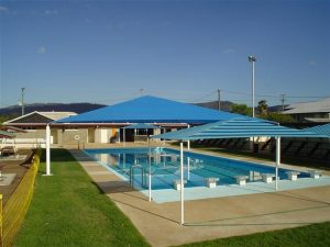 Blue striped shade structure over pool