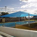 Blue striped shade structure over pool